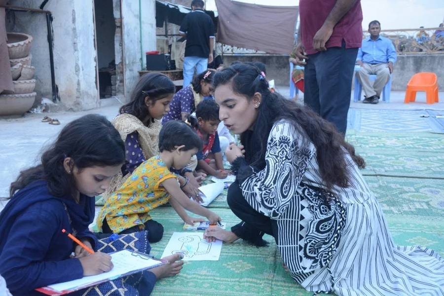 Volunteer helping a child with a drawing